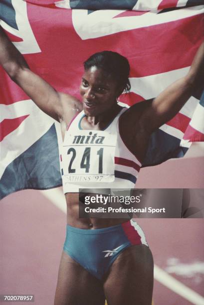 English track and field athlete Denise Lewis holds up the union jack national flag after finishing in 2nd place to win the silver medal in the...