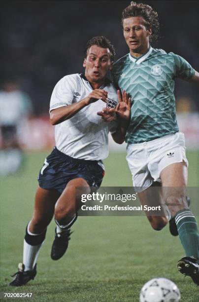 England footballer David Platt leans in to tackle German defender Guido Buchwald during the 1990 FIFA World Cup semi final match between West Germany...