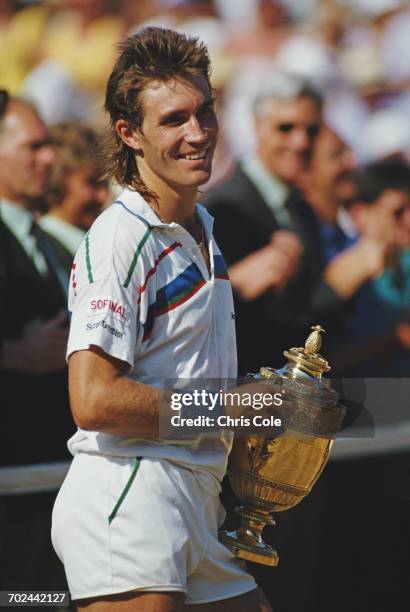 Pat Cash of Australia holds aloft the Gentlemen's Singles Trophy after winning the Men's Singles Final against Ivan Lendl at the Wimbledon Lawn...