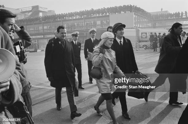 The Beatles at London Airport, en route to America, 13th February 1964. Pictured are John Lennon and his wife Cynthia Lennon with manager Brian...
