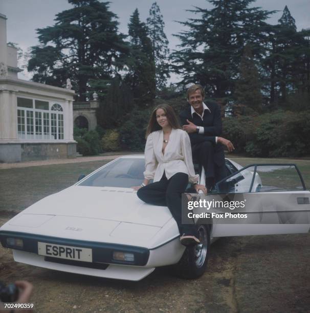 Actors Barbara Bach and Roger Moore, stars of the James Bond film 'The Spy Who Loved Me', sitting on the now-famous 'amphibious' Lotus Esprit at...