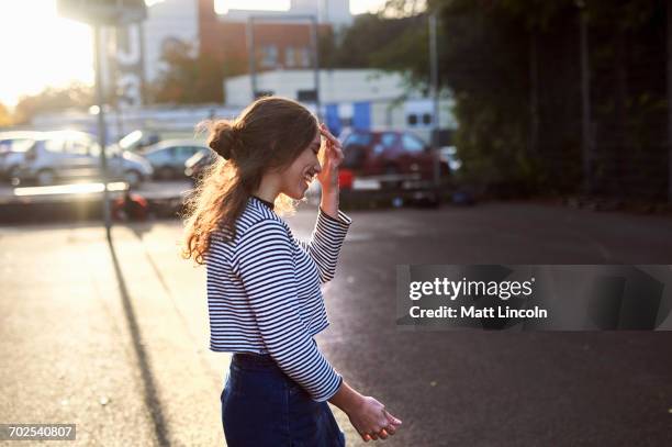 young woman walking on sunlit street - bristol england photos et images de collection