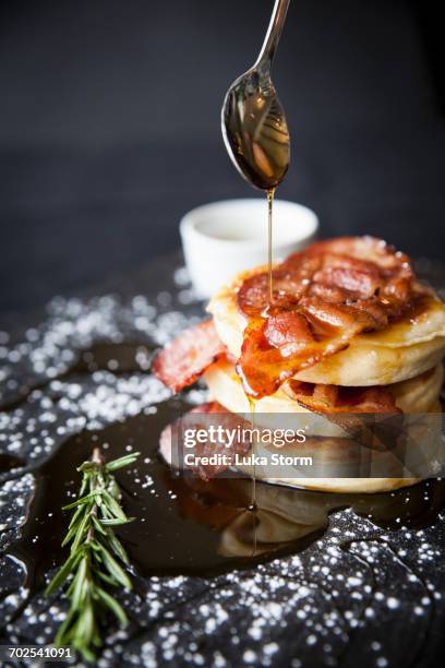 breakfast bacon crumpet with maple syrup pouring from spoon onto slate - crumpet fotografías e imágenes de stock