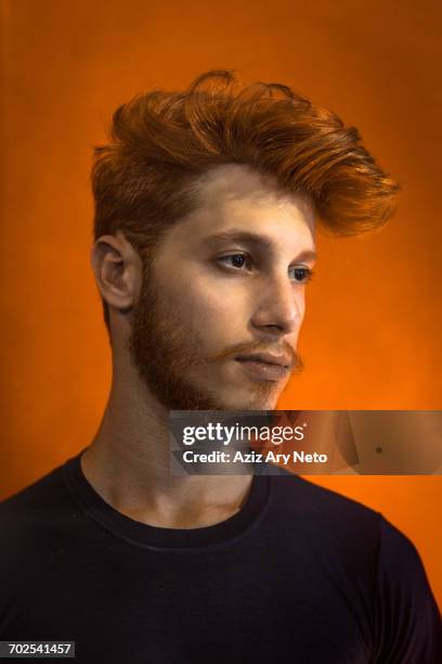 portrait of young man with red hair against orange background - pompadour imagens e fotografias de stock