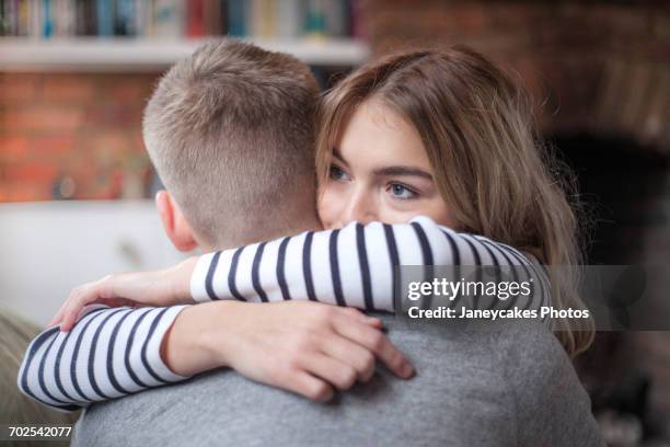 young couple hugging, indoors, close-up - weakness stock pictures, royalty-free photos & images