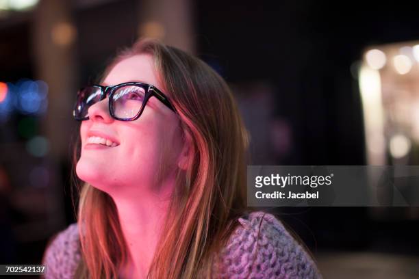 young woman enjoying bright neon lights of street, london, uk - looking up stock pictures, royalty-free photos & images