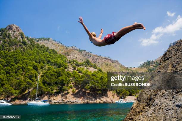 young man diving into sea, cala tuent, majorca, spain - sierra de tramuntana stock pictures, royalty-free photos & images