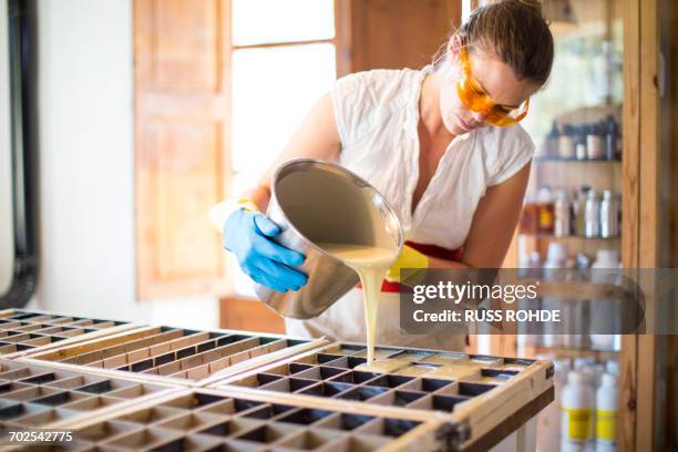 young woman pouring liquid into soap mould in handmade soap workshop - bar of soap stock pictures, royalty-free photos & images