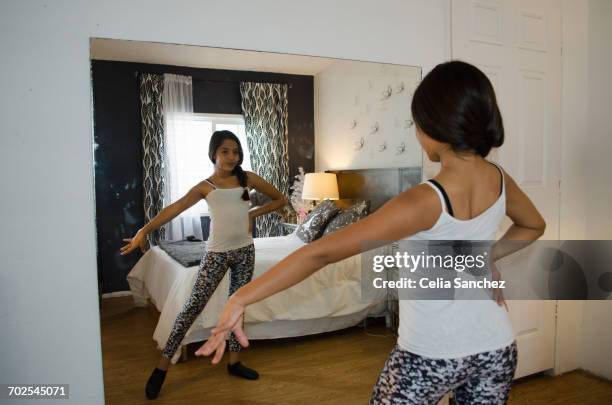 young girl at home, practising dance moves in front of mirror - girls in leggings stock-fotos und bilder