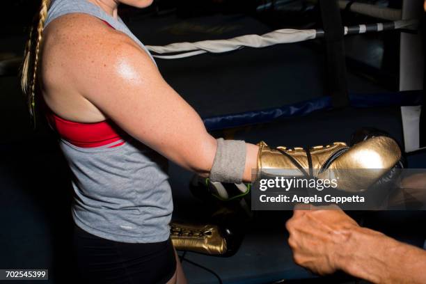 trainer tying boxing glove laces for female boxer in gym - boxing glove stock pictures, royalty-free photos & images