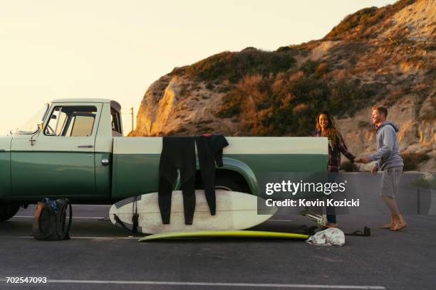 surfing couple with pickup truck at newport beach, california, usa - newport beach california stock-fotos und bilder