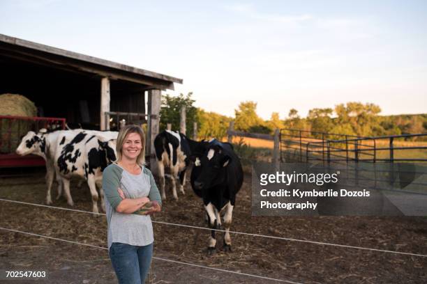portrait of female farmer on farm, cows in background - female animal stock pictures, royalty-free photos & images
