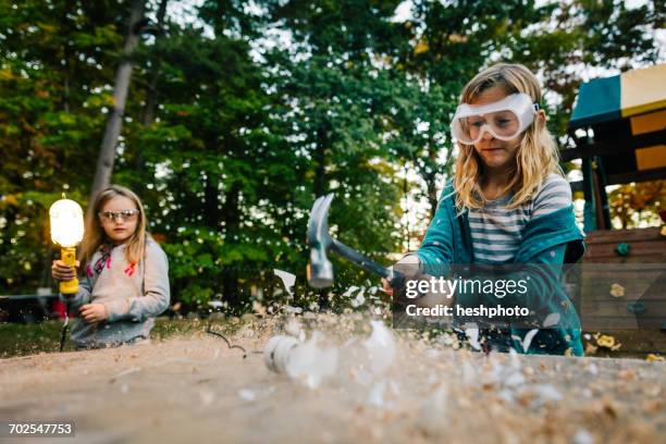 girl smashing lightbulb with hammer on garden table at dusk - heshphoto - fotografias e filmes do acervo