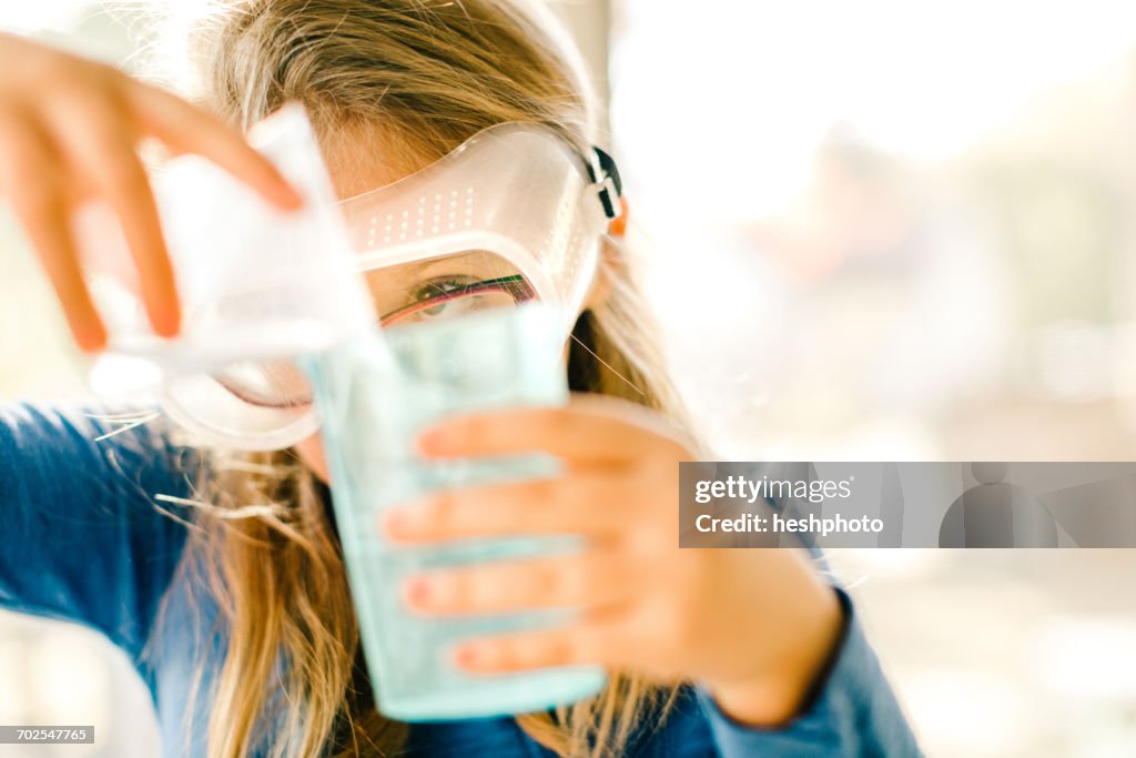 Girl doing science experiment, pouring liquid