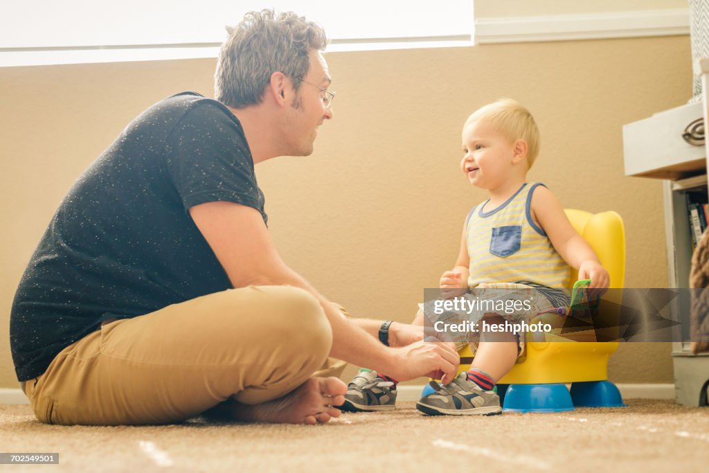 Father and young son, face to face, father dressing son