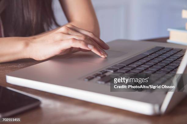 womans hand on laptop computer touch pad - touchpad stock-fotos und bilder