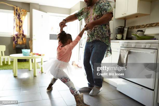 father and daughter jiving in kitchen - papa niña baile fotografías e imágenes de stock