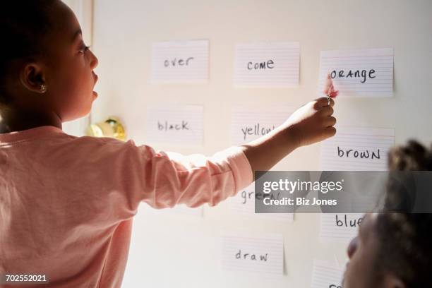 girl with father pointing at words on wall - jogo de palavras imagens e fotografias de stock