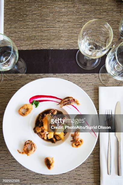 seafood dish garnished with fried calamari - dining presentation food stock-fotos und bilder