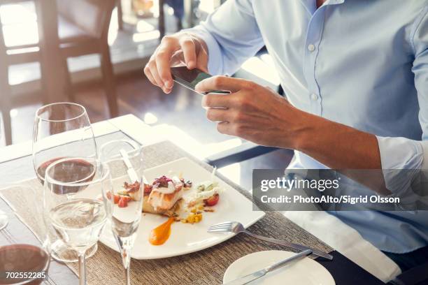man using smartphone to photograph his food in restaurant - connoisseur stock pictures, royalty-free photos & images