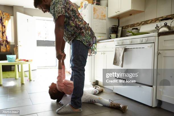 father and daughter jiving in kitchen - danser le rock photos et images de collection