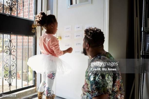 girl in tutu with father reading words on wall - jogo de palavras imagens e fotografias de stock