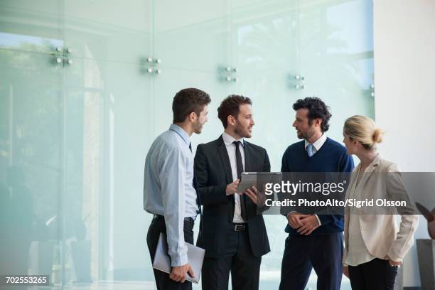 business associates collaborating using digital tablet - four people stock pictures, royalty-free photos & images