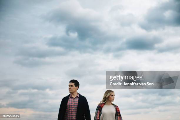 young couple outdoors, looking in different directions - streiten stock-fotos und bilder
