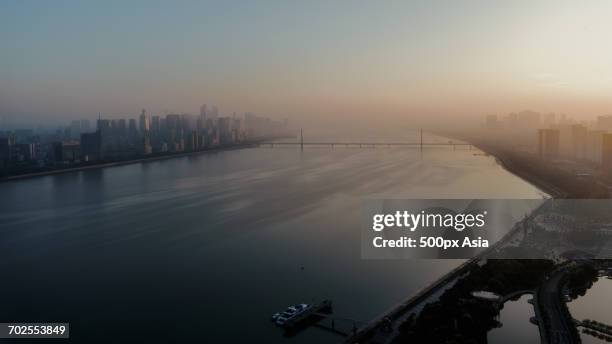 city river shrouded in fog - many cities in china shrouded in fog photos et images de collection