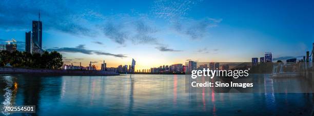 city river in front of skyscrapers at dusk - 合肥 ストックフォトと画像