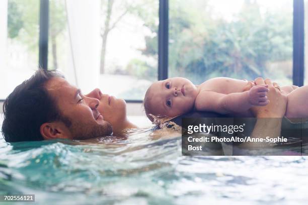 parents with infant in swimming pool - baby swim imagens e fotografias de stock