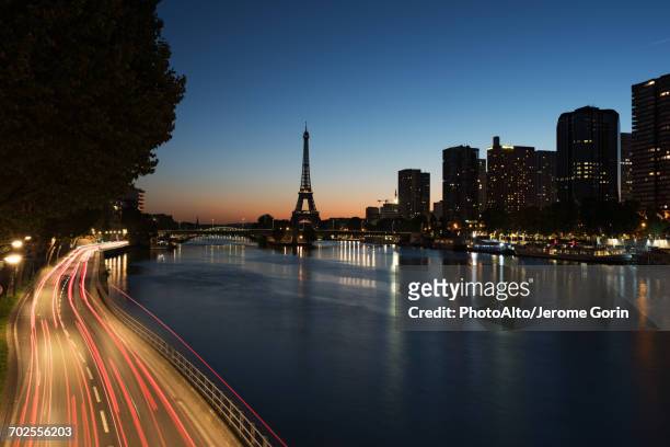 light trails on a street along the river seine at twilight, paris, france - phare arrière de véhicule photos et images de collection