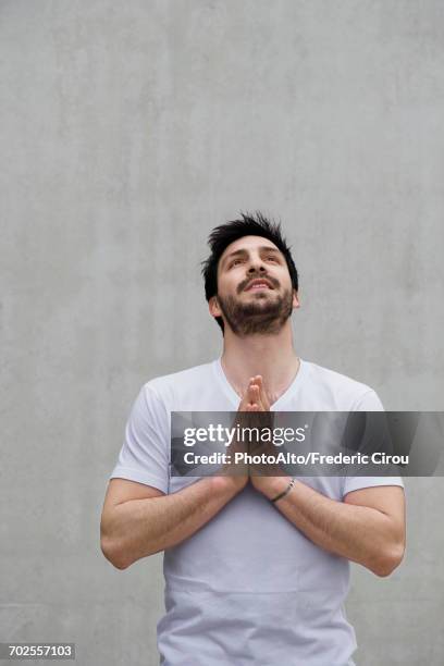 man with hands together, looking up - ersuchen stock-fotos und bilder