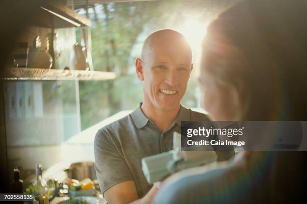 smiling husband giving gift to wife - wife birthday stock pictures, royalty-free photos & images