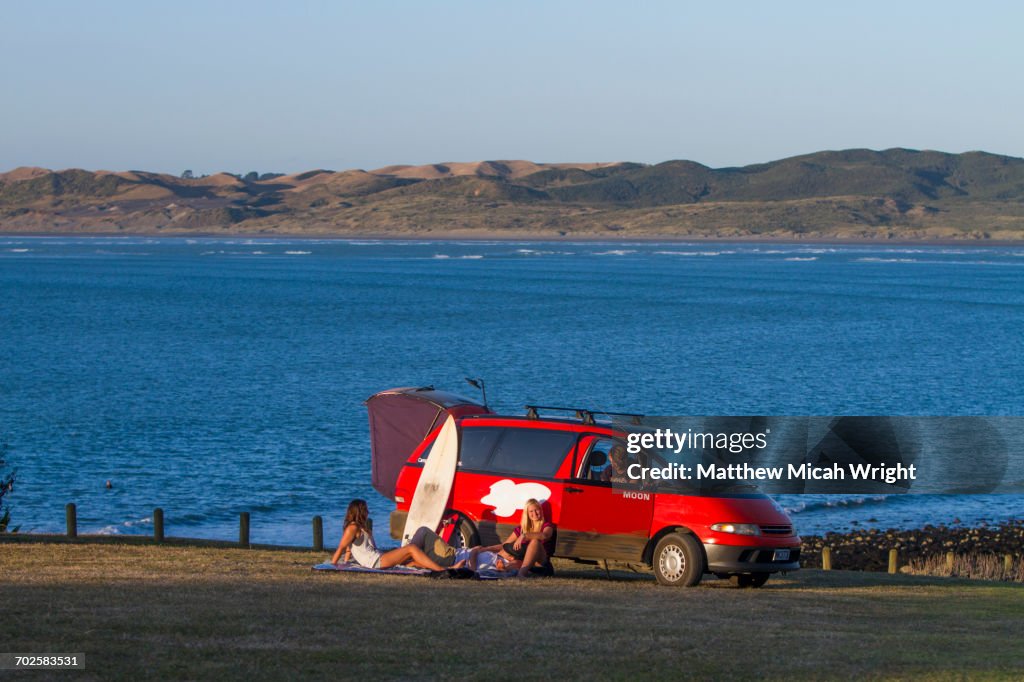 Surfers relax at a beachfront camp.