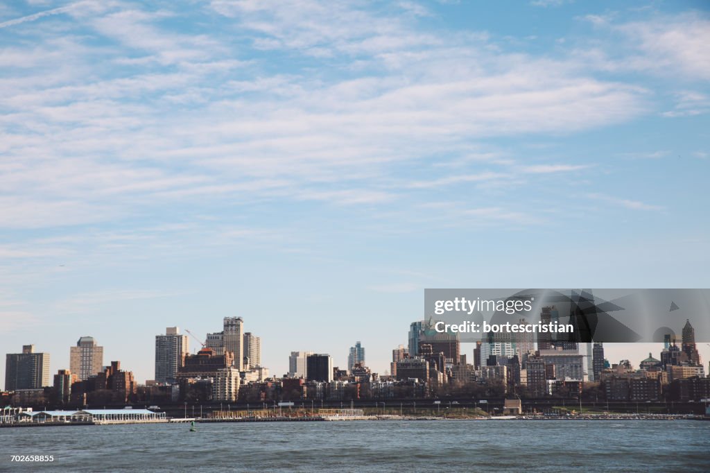 City At Waterfront Against Cloudy Sky