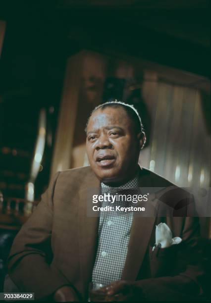 American trumpeter and singer Louis Armstrong at the Mayfair Hotel in London, circa 1960.