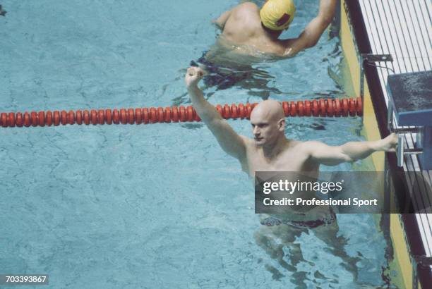 English swimmer Duncan Goodhew raises one arm in the air in celebration after finishing in first place to win the gold medal for the Great Britain...