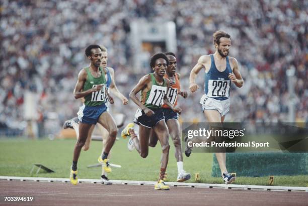 View of athletes competing in the final of the Men's 10,000 metres event, with Lasse Viren of Finland leading bronze medal winner Mohamed Kadir of...