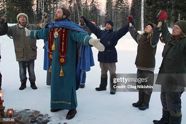 Inhabitants of Sun City in eastern Siberia pray March 2, 2002 in the morning with Vissaron, a religious cult figure who claims that he is the...