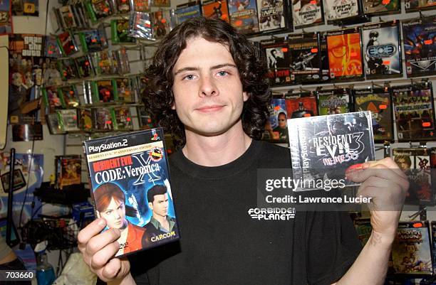 Forbidden Planet manager Jeff Ayers shows two generations of the video game "Resident Evil" March 15, 2002 in New York City. Critics have denounced...