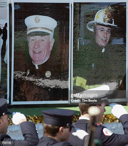 Chicago and New York City firefighters salute as they stand near a float honoring the late New York City Fire Department Chaplain Rev. Mychal Judge...