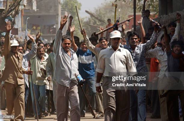 Mob of Hindus wielding swords and sticks back off after Indian Rapid Reaction Force officers stopped them from attacking a small group of Muslims...