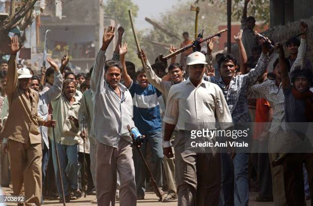 Mob of Hindus wielding swords and sticks back off after Indian Rapid Reaction Force officers stopped them from attacking a small group of Muslims...