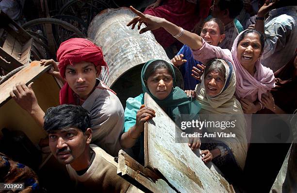 From behind a makeshift barricade, Muslims beg members of the news media and the Indian Rapid Reaction Force Police to protect them from a mob of...