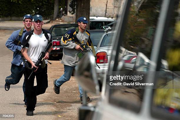 Israeli police run through a residential neighborhood searching for a possible second gunman after a Palestinian militant opened fire on young...
