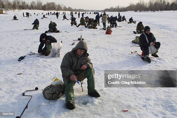 Men fish while sitting on the ice of the river Ob March 3, 2002 in Novosibirsk, East Siberia, Russia.