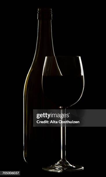 wine glass and bottle on black background rim lighting - classe alta stock-fotos und bilder