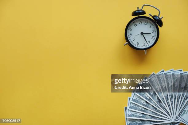 alarm clock and american one hundred dollar bills. debica, poland  - wasting time and money stock pictures, royalty-free photos & images