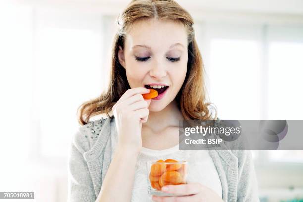 woman eating dried fruit - dried food stock pictures, royalty-free photos & images